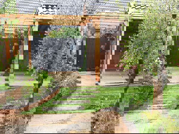 Gezinsvriendelijke tuin met veranda en sfeervolle elementen in Obdam