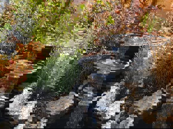 Smalle lange tuin aan het water met pergola's